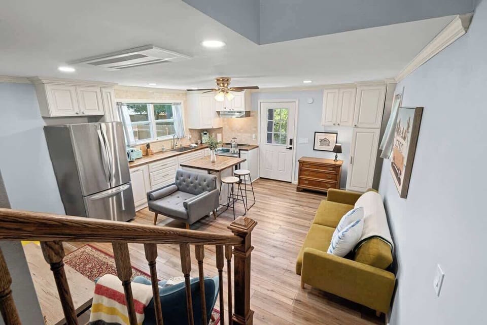 Open living area w/ sofa seating flowing into kitchen & dining space