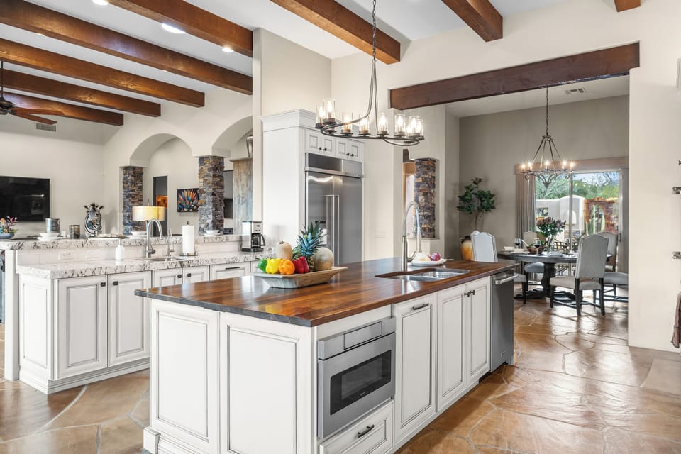 Bright chef’s kitchen with a warm wood island overlooking the dining area.