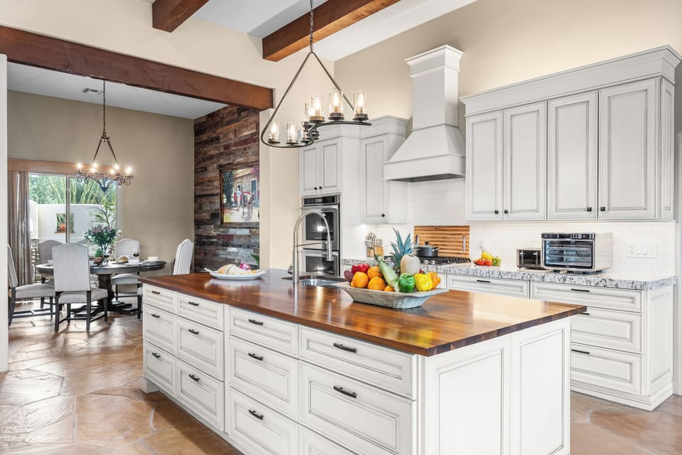Bright chef’s kitchen with a warm wood island overlooking the dining area.