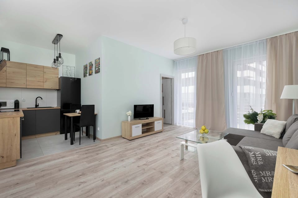 Bright modern living room with sofa, coffee table and open kitchen area.