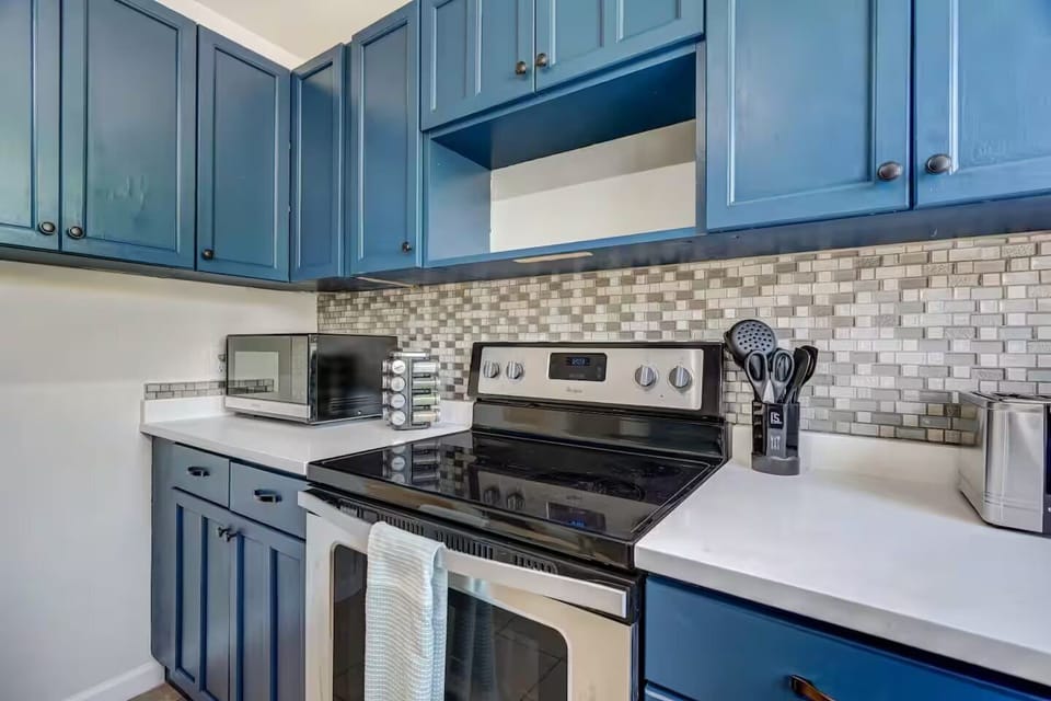 The fully stocked kitchen includes modern appliances, cookware, utensils, dinnerware, and basic cooking essentials
