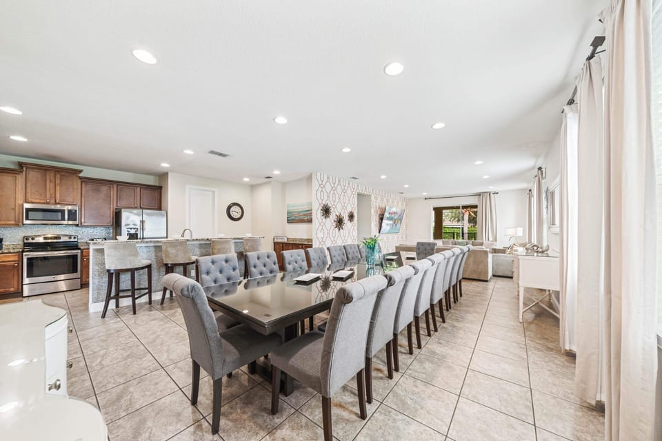 Gather around the long dining table in this open kitchen & living space filled w/ natural light