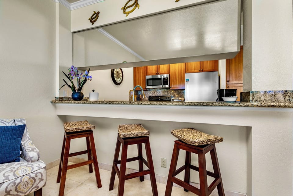Gather at the breakfast bar with its granite countertop and woven stools, where you can enjoy morning coffee while chatting with the chef in your fully equipped kitchen.