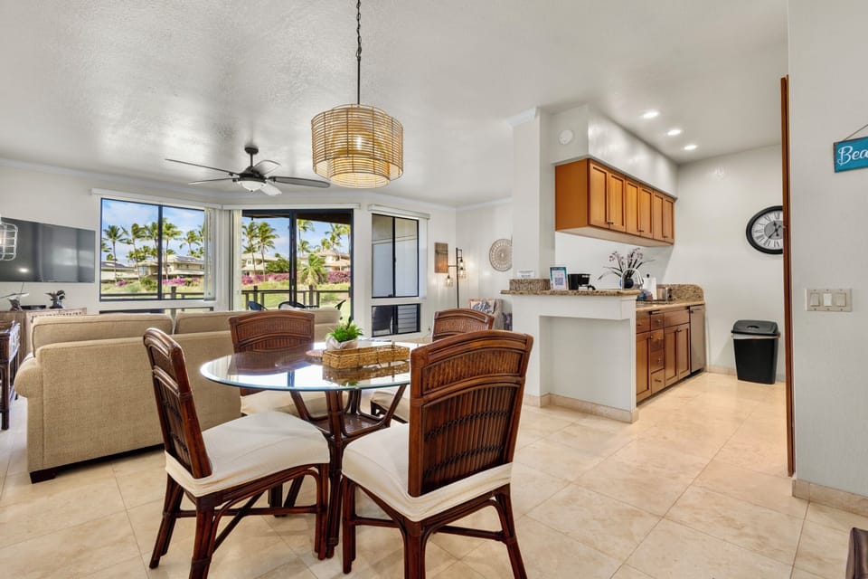 Step into your open-concept living space where tropical breezes flow through large windows, inviting you to dine at the cozy table or unwind by your kitchenette—your island retreat awaits.