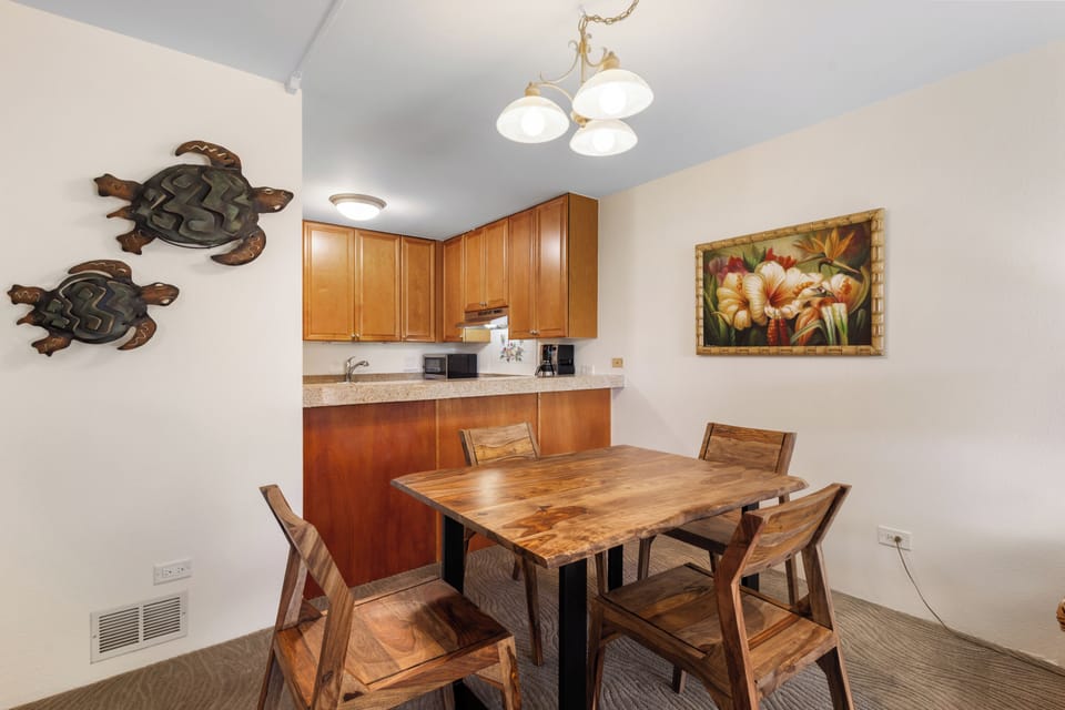 Gather around this inviting dining space, where warm wood tones and tropical-inspired decor create the perfect setting for your morning coffee or evening meals together.