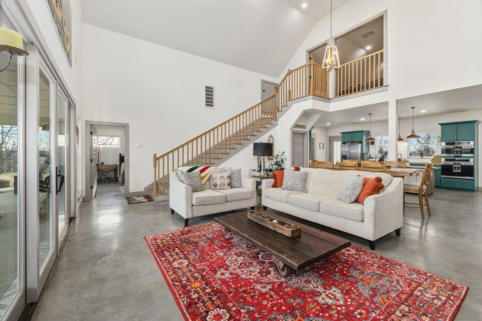 Our living room is complete with high ceilings, large windows, comfy seating and a large Smart TV.