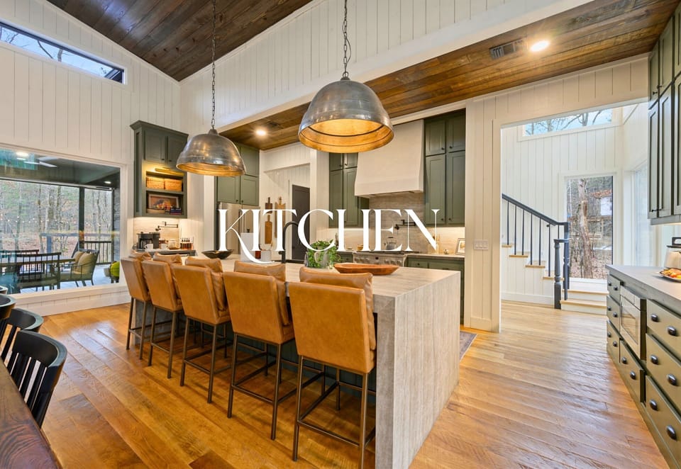 The kitchen island offers generous seating and modern lighting, making it a natural gathering point for snacks and casual meals.
