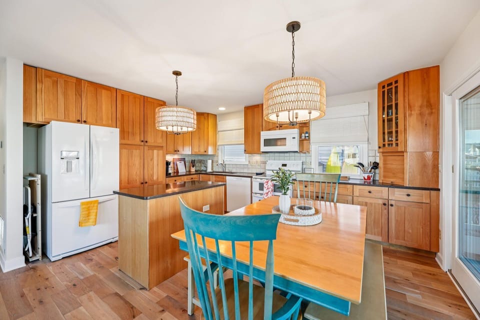 Gather around this bright kitchen island for morning coffee or meal prep. Warm wood cabinetry and pendant lighting create a cozy, homey feel for your stay.