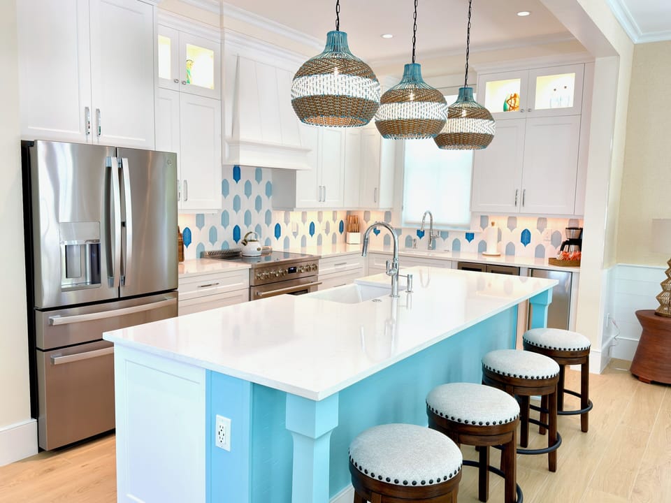 Open-concept kitchen with island seating, appliances, and coastal-modern style