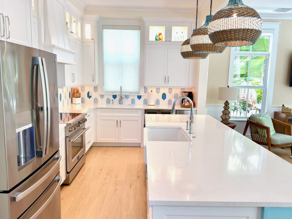 Open-concept kitchen with island seating, appliances, and coastal-modern style