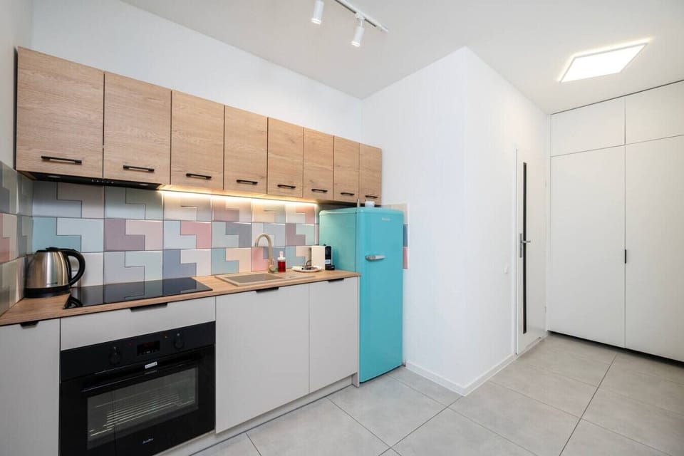 Modern Open-Plan Kitchen and Dining Area with Fully Equipped Kitchen, Retro-Style Fridge and Dining Table for Shared Meals | Book Now with RENTUJEMY.COM