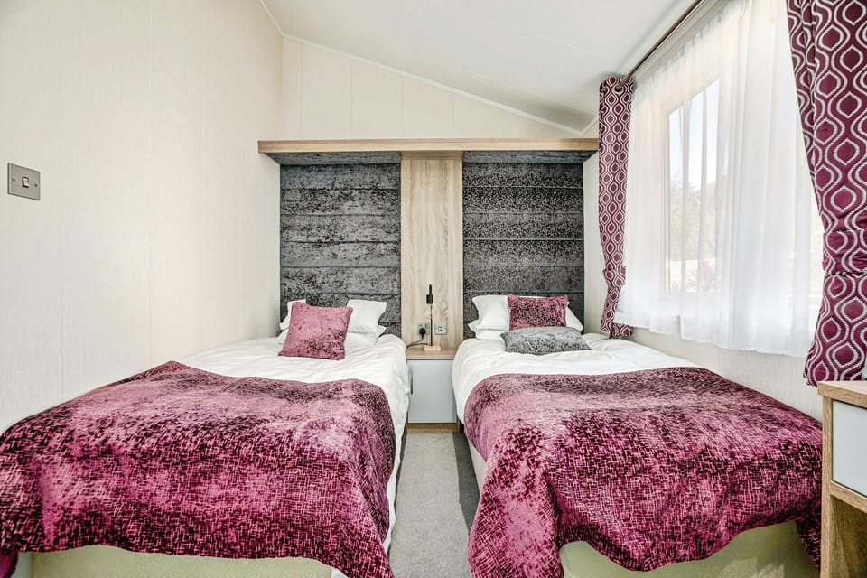 Bedroom with two single beds, small bedside unit and lamp