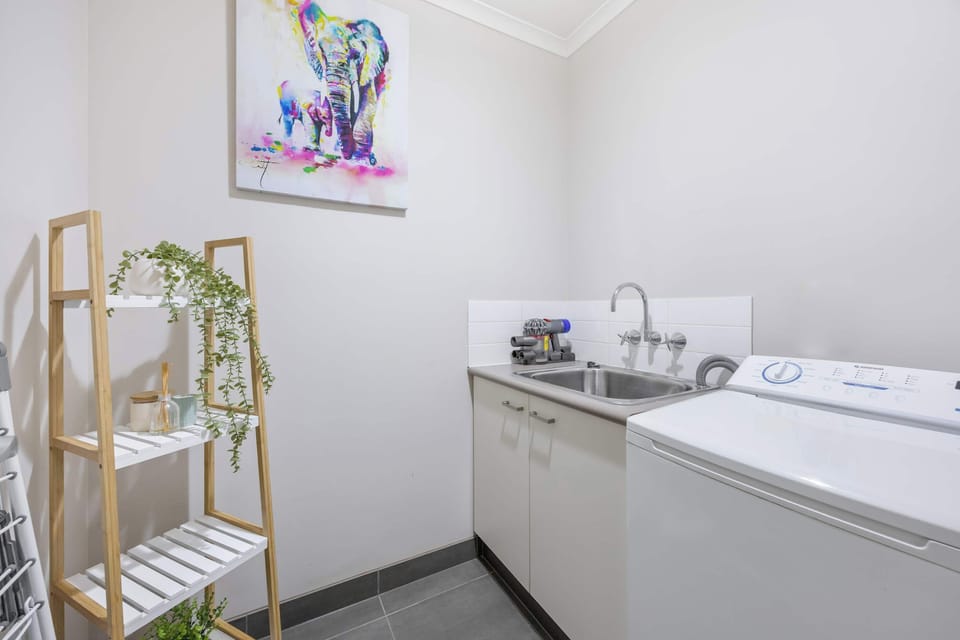 Laundry with washing machine and trough.