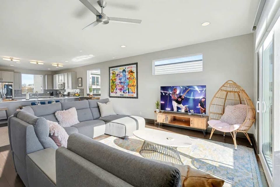 2nd Floor: Bright and open living area with cozy furnishings, a smart TV, Twin daybed with a Twin trundle, and a private balcony.