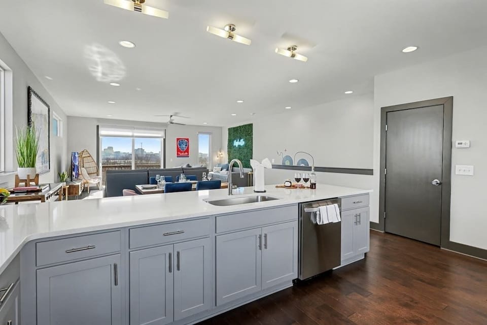 2nd Floor: Fully equipped kitchen with stainless steel appliances, ample counter space with seating for 4 guests, and a workstation with a monitor and desk chair.