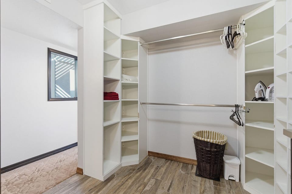 Primary bedroom featuring a King bed, large walk-in closet, access to a private patio, and an en-suite bathroom.