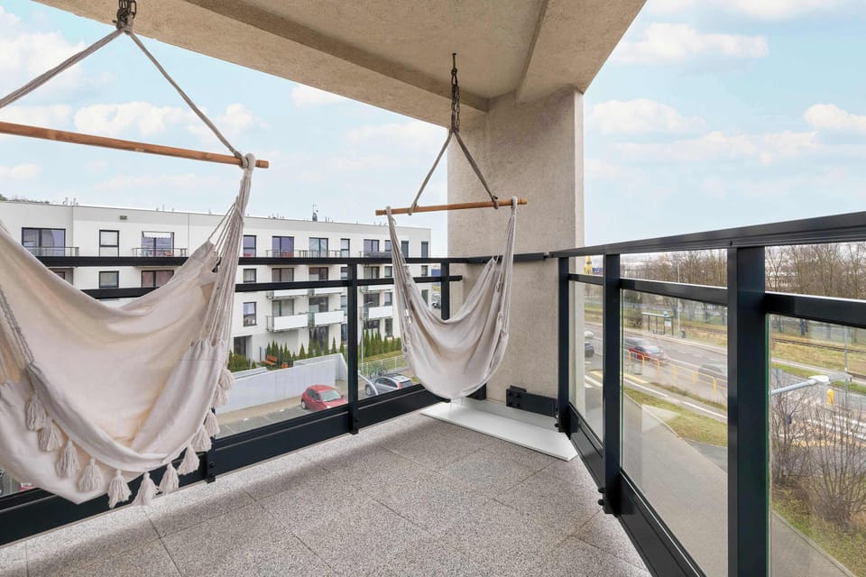 Relaxing balcony with outdoor seating and light canopy, ideal for enjoying fresh air.