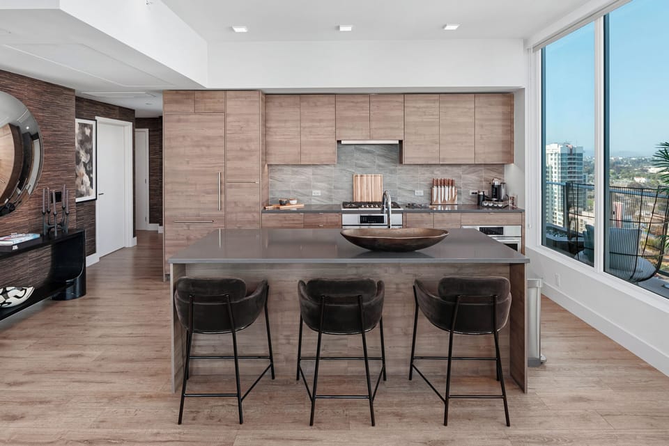Kitchen featuring light wood cabinetry, a large island, and bar seating.