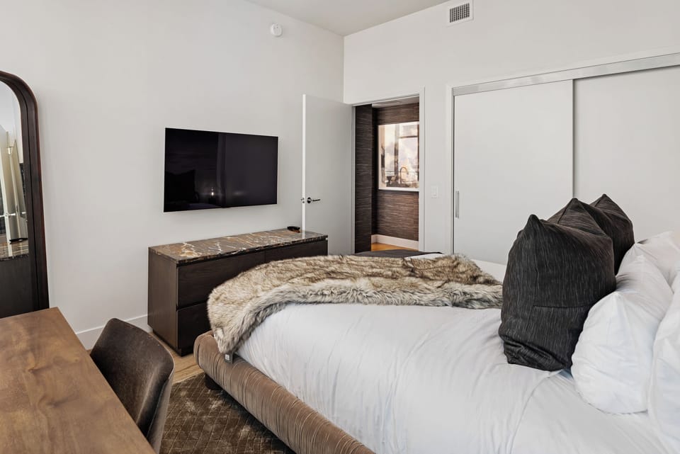 Bedroom 2 features a TV and a laptop-friendly table.