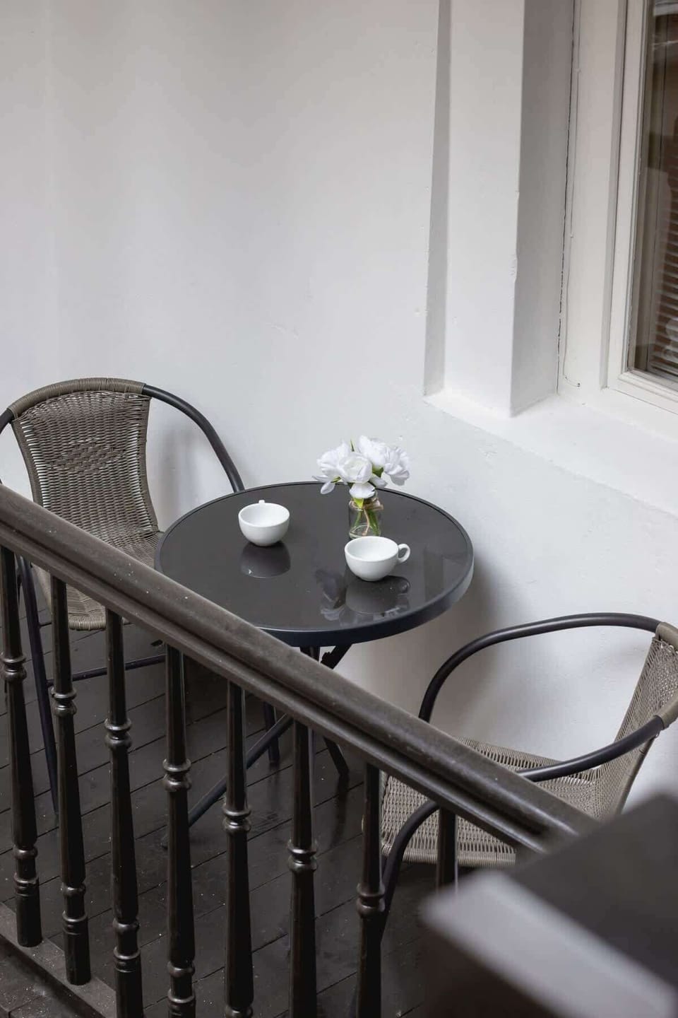 Small balcony with iron railing overlooking the courtyard. Ideal spot for fresh air and morning coffee.