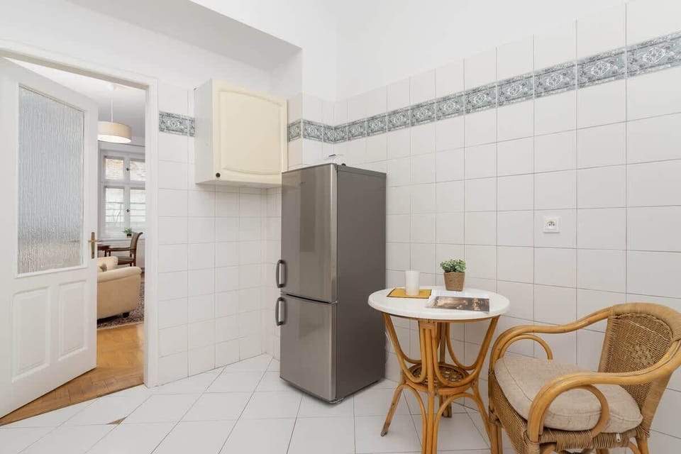 Kitchen with a refrigerator and a small dining corner. A practical solution for quick meals.