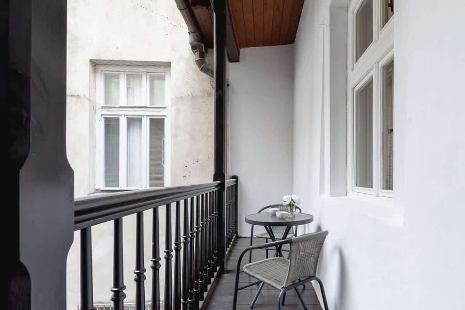 Balcony with two chairs and a table, perfect for morning coffee.