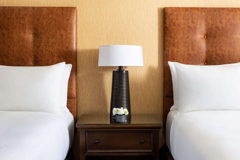 Twin beds with shared table and soft bedside lighting
