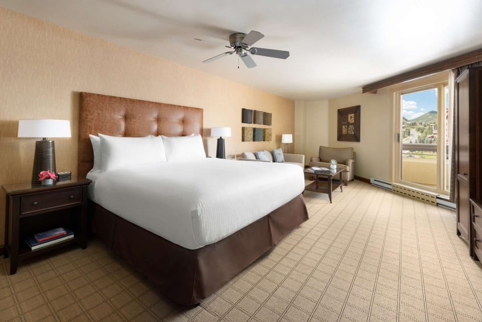 Bright king bed room with sofa seating and large windows