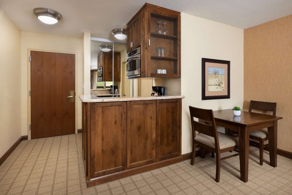 Kitchen area with cabinets, coffee maker, and dining table