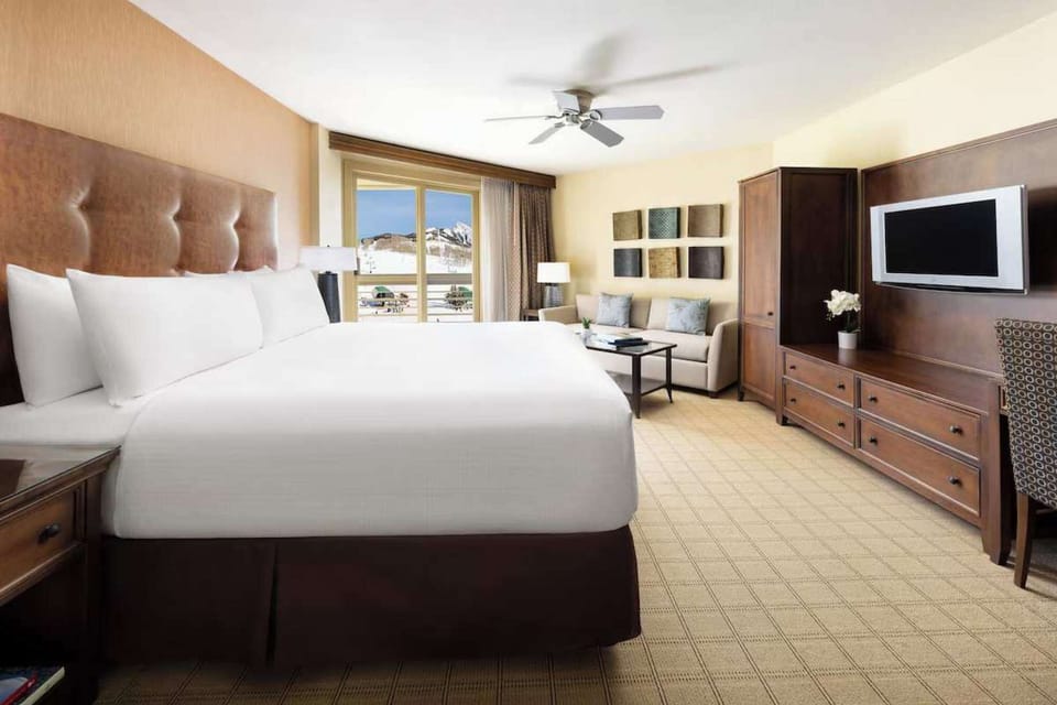 Comfortable king bed with seating area and desk