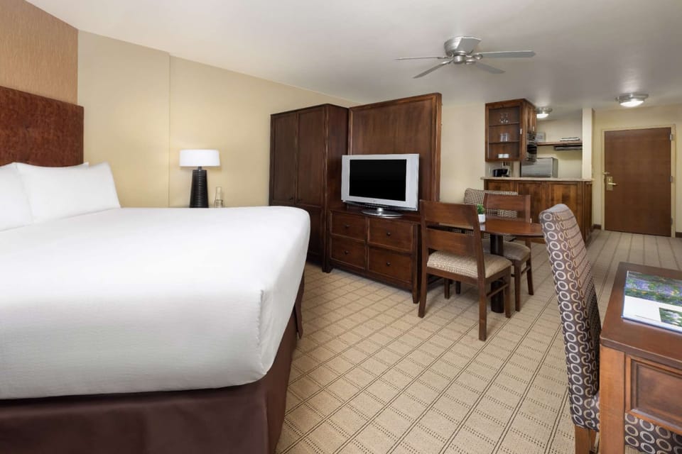 King bed with dining area and kitchenette nearby