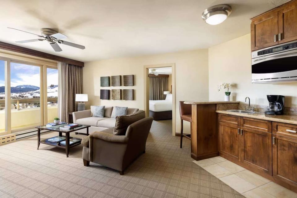 Living room with kitchen, seating area, and balcony access