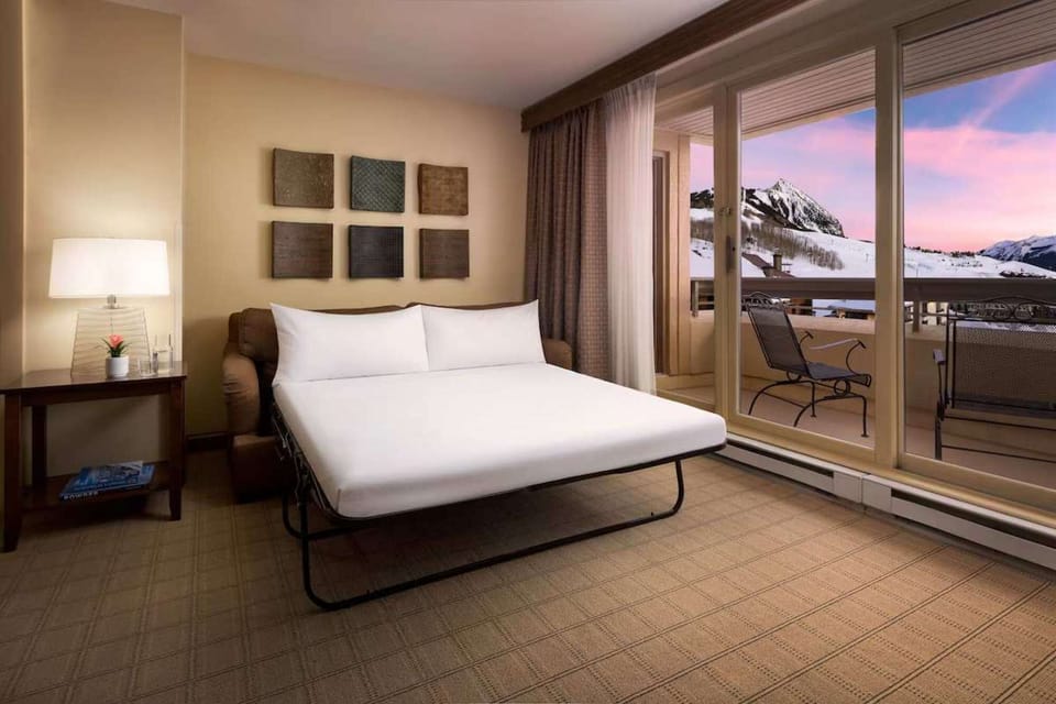 Sofa bed set up near balcony with snowy mountain view
