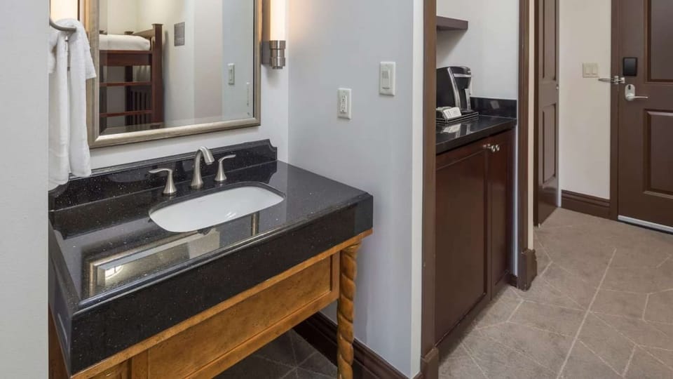 Bathroom with black granite sink and wooden cabinet base