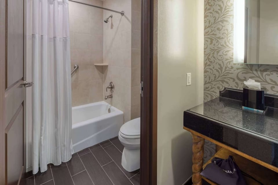 Bathroom with tub, shower, and granite vanity with lit mirror