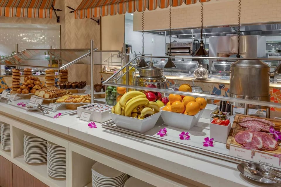 Buffet spread with fruits, pastries, meats, and fresh bread