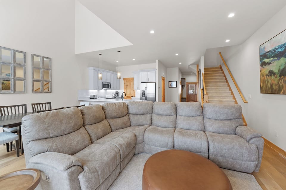 Sink into your spacious sectional sofa in this bright, open-plan living space where modern comfort meets mountain charm perfectly.