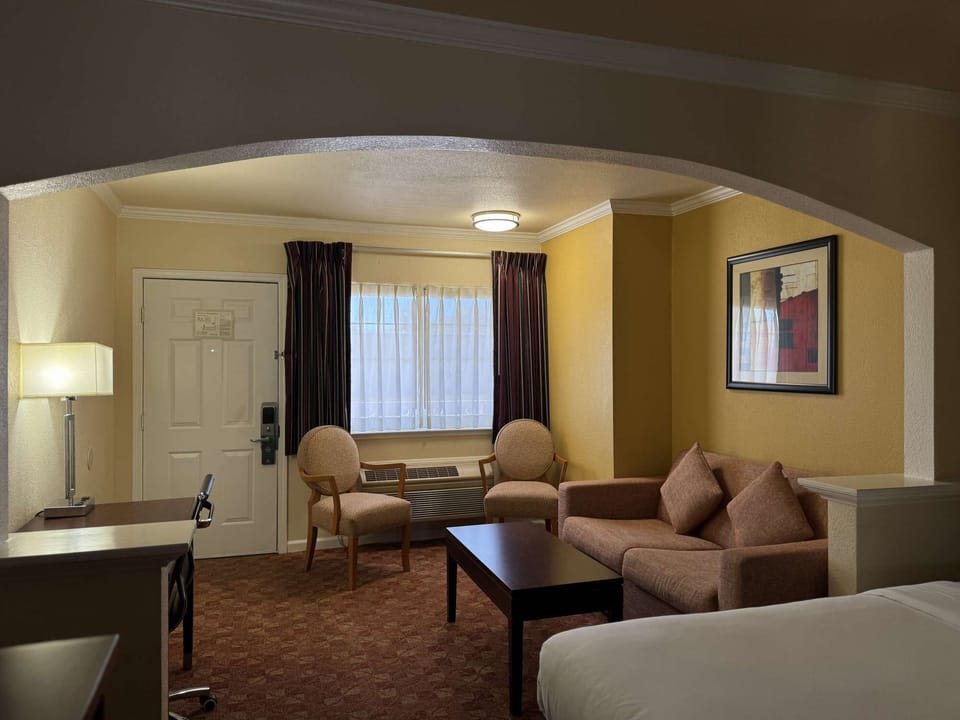 Cozy room with sofa, work desk, and soft lighting near window