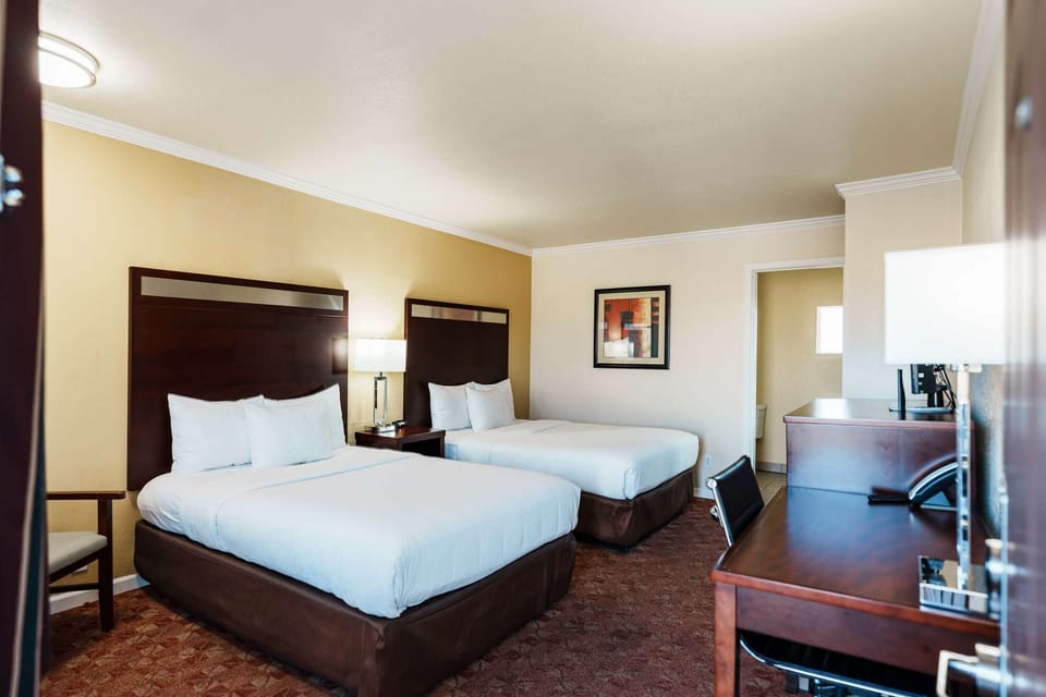 Cozy room with two beds, desk, and warm lighting