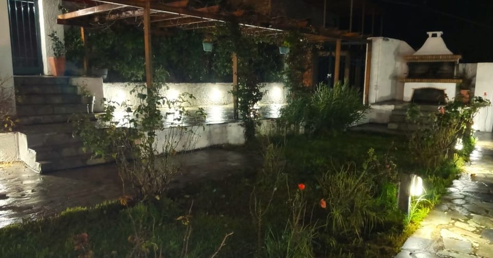 Beautifully lit garden area with pergola and outdoor barbecue.