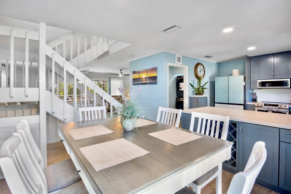Your open-concept kitchen and dining space features modern blue cabinetry, stainless appliances, and a welcoming dining table for memorable meals.