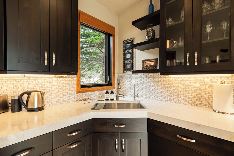 Modern kitchen with stainless appliances and stone counters.