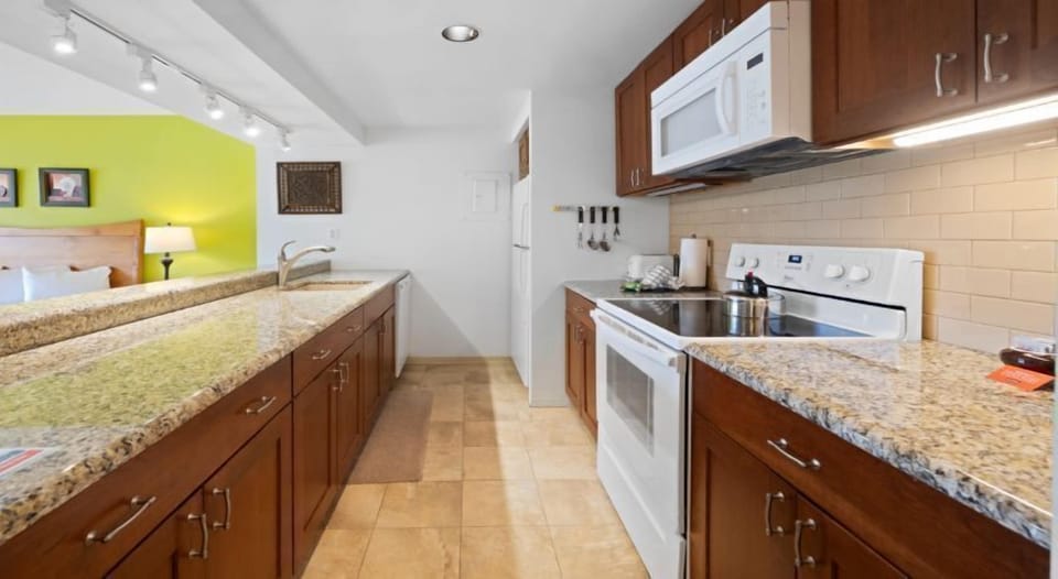 The well-equipped kitchen showcases beautiful granite countertops and modern appliances, perfect for all your culinary adventures.