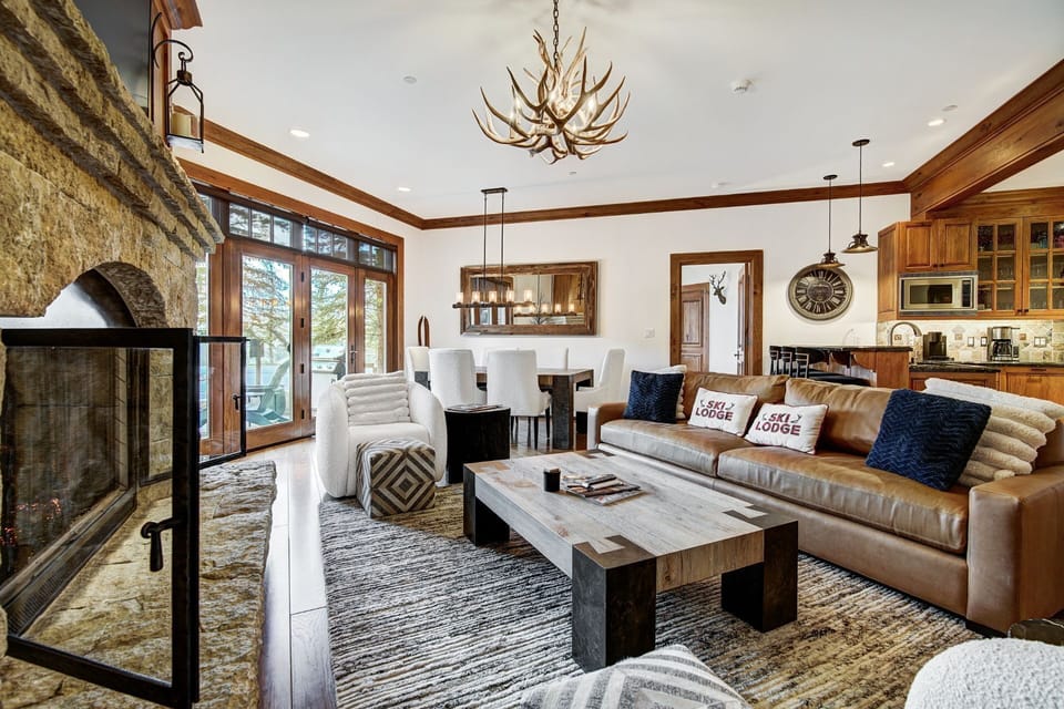 This elegantly appointed living space features a cozy blend of rustic stonework and modern comforts, complemented by stunning views of the surrounding alpine scenery.