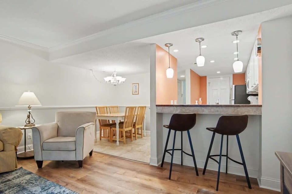 Relax in your open-concept living space featuring a modern kitchen with breakfast bar and cozy seating area perfect for unwinding.