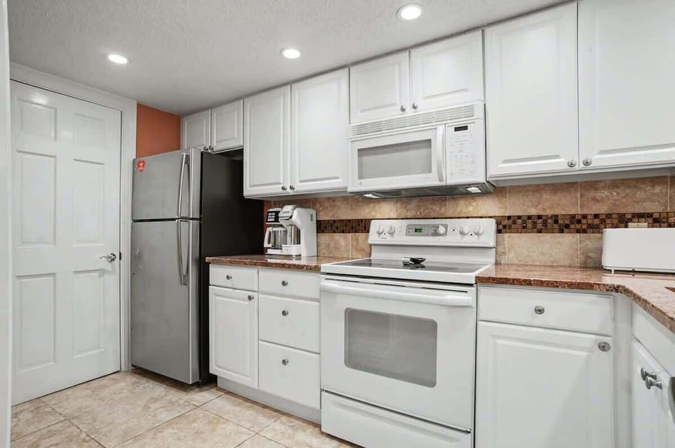 Your fully equipped kitchen awaits with granite counters, white appliances, and everything you need to create memorable meals during your stay.