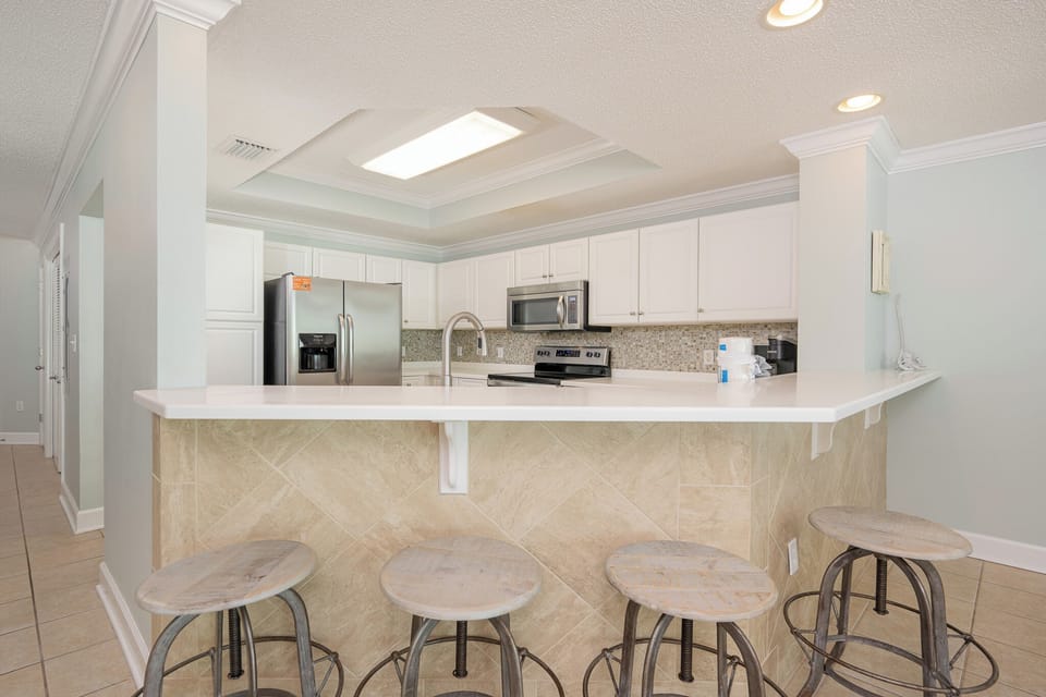 Feel the comfort of morning light as you sip coffee at the breakfast bar with rustic stools nearby