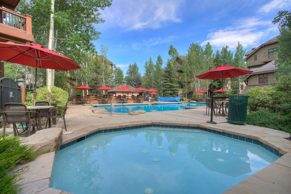 Dive into relaxation by the sparkling pool, set against a backdrop of lush greenery.