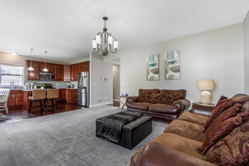 Comfortable living room w/ leather seating, TV, & open layout near the kitchen.