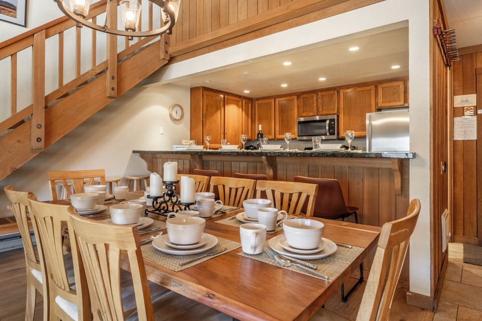 Gather around this beautifully set dining table for memorable meals with loved ones in this warm, open-concept space.